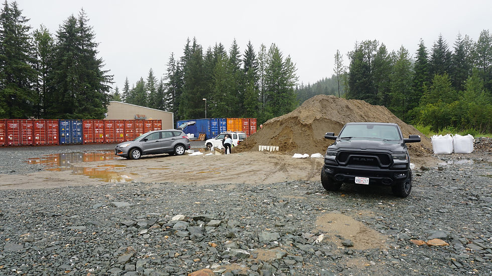 People fill sandbags from a pile in the Dimond Park Field House parking lot on Monday, Aug 11, 2025. (Ellie Ruel / Juneau Independent)