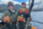 Ardel Williamson and Rylan Armstrong hold up Dungeness crab onboard Andrew Friske's fishing boat Adria, today. (Photo provided by Andrew Friske)