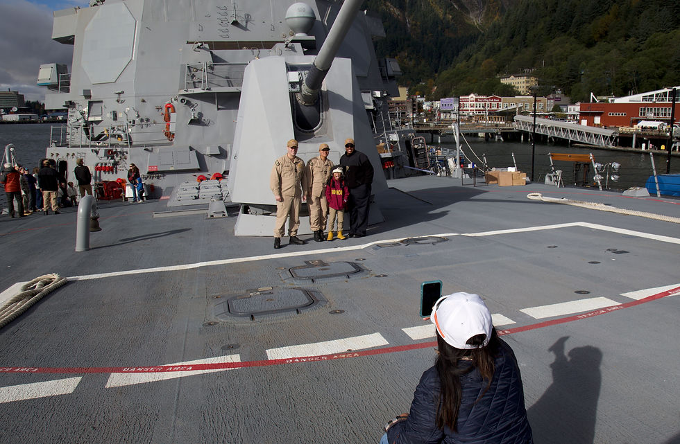 Christian Salva takes a photo of her son, Jethro, 9, with USS Ted Stevens crew members Regina White, Matthew Lemaster and Milly Rodriguez on Thursday, Oct. 8, 2026. (Mark Sabbatini / Juneau Independent)