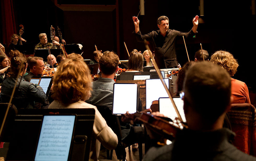Troy Quinn guides the Juneau Symphony through a rehearsal of its "TV Classics" concert at Juneau-Douglas High School: Yadaa.at Kalé on Thursday, Oct. 3, 2026. (Mark Sabbatini / Juneau Independent)