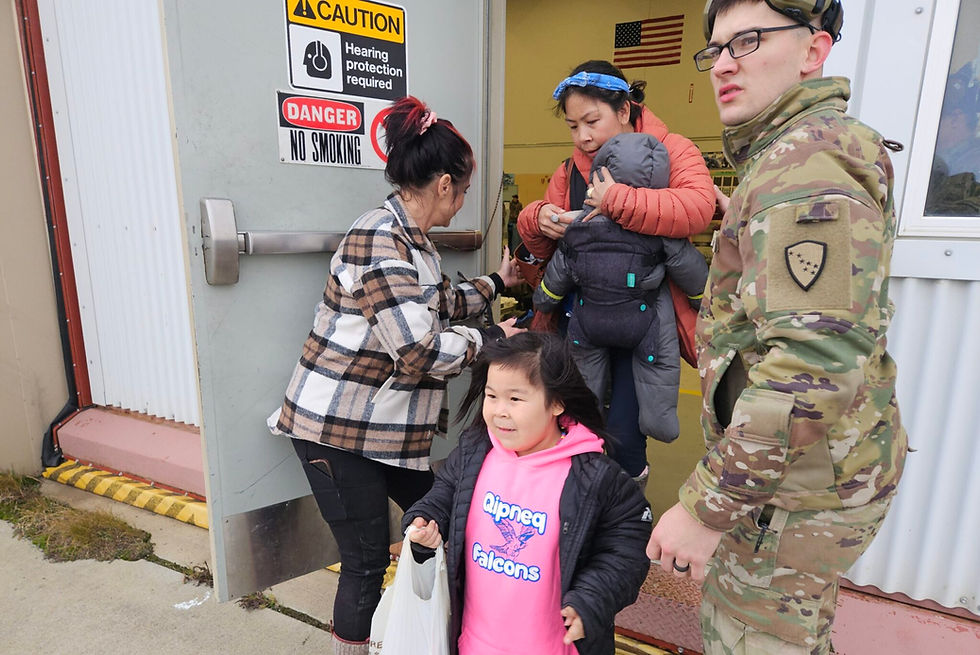 A family is seen stepping out onto the runway in Bethel to board the first evacuation flight to Anchorage on Oct. 15, 2025 (Corinne Smith/Alaska Beacon)