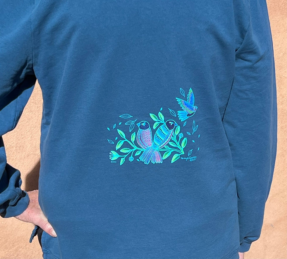 Thumbnail: a woman wearing a blue sweatshirt with a pattern of bright blue birds and foliage
