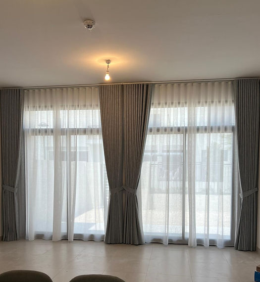  A cozy living room featuring elegant curtains and a comfortable chair, creating a warm and inviting atmosphere