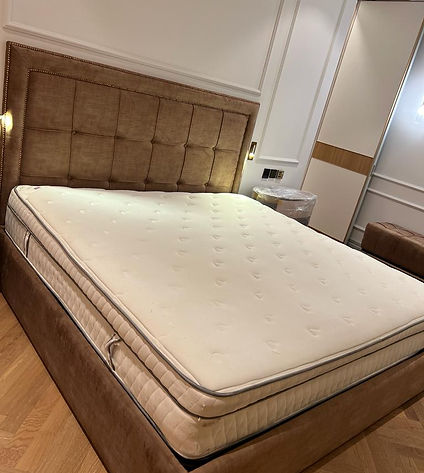A neatly arranged bed with a cushioned mattress for ultimate comfort. 