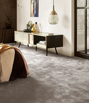 A spacious bedroom featuring a large bed and a wide window, allowing natural light to fill the room