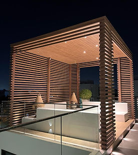 A contemporary wooden rooftop structure illuminated at night, showcasing modern design.