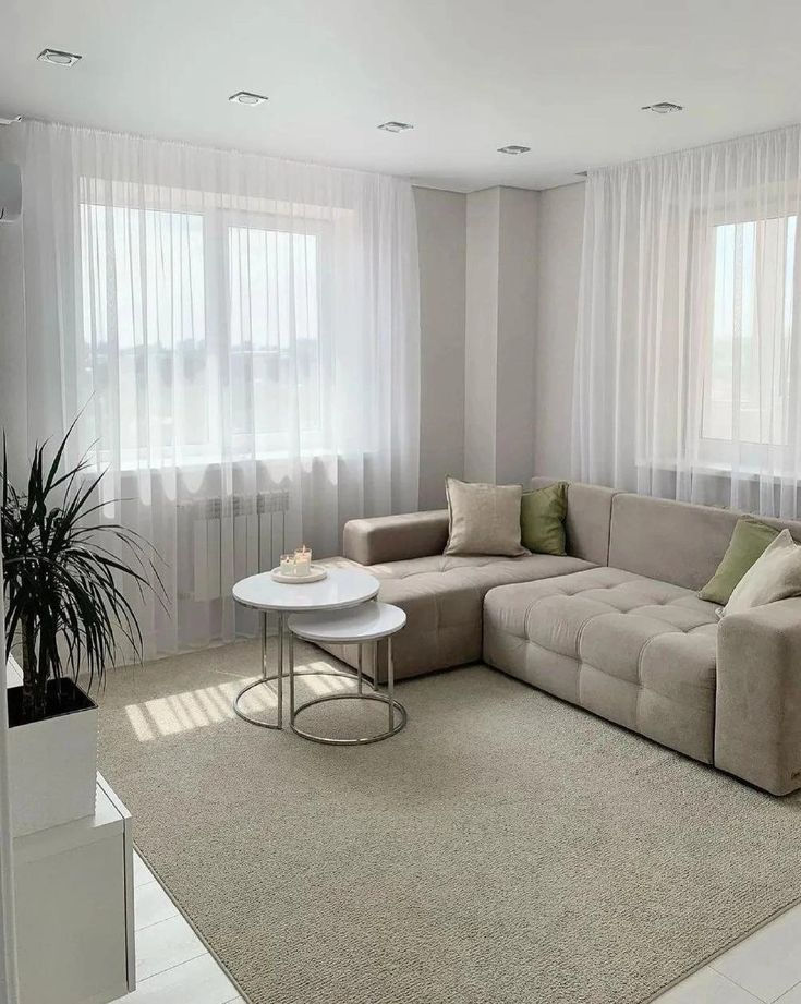 A cozy living room with a comfortable couch, a stylish coffee table, and a large window offering natural light.