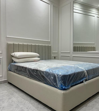 A cozy bedroom with a comfortable bed and a mirror on the wall.