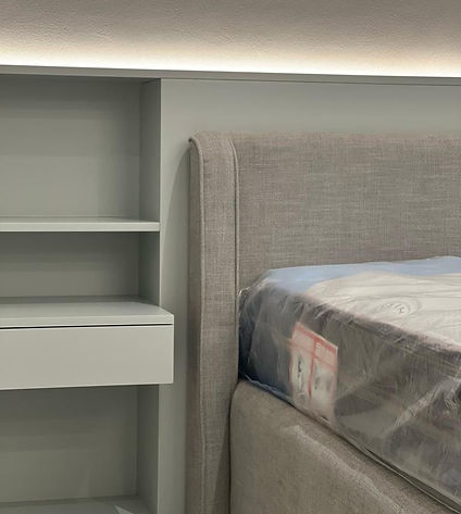 A stylish bed accompanied by a nightstand and a shelf above it, adding storage options and a decorative element to the bedroom ambiance.