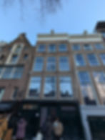 Row of historic brick buildings, and Anne Frank Huis, under a clear blue sky. Anne Frank House.