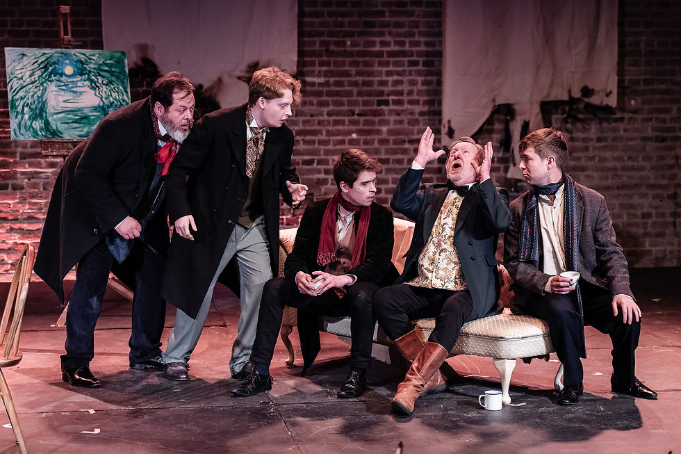 Three men sat on a chaise lounge, with two stood. They all lean in toward one man, who has his hands in the air.