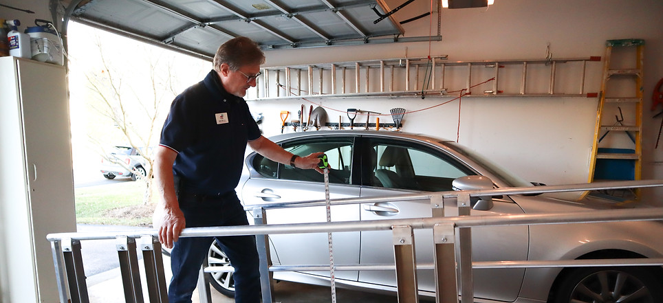 Technician measuring for a modular garage ramp