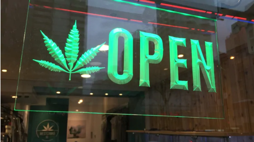 Green neon OPEN sign with a cannabis leaf