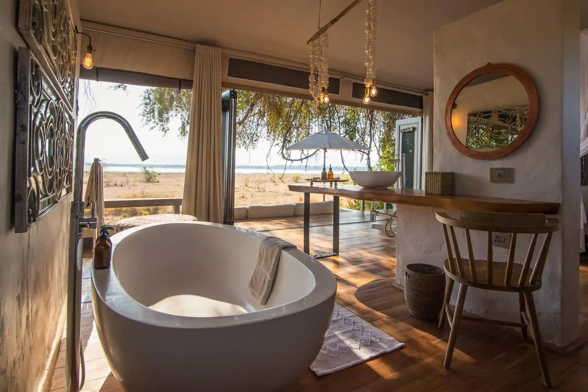 Bath overlooking private lounge deck and views of Mana Pools