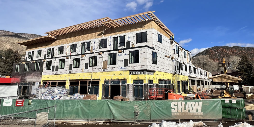 Construction progress photo of The Midland Residences at Basalt Center Circle in December 2025. The three-story structure is partially clad and framed, with visible insulation wrap and open storefronts, as crews work to bring Z Group’s community-focused, modular vision to life in the heart of Basalt.