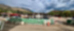 Panoramic view of the Basalt Center Circle construction site, with Shaw Construction fencing, earthwork in progress, heavy machinery on site, and surrounding mountain backdrop under dramatic Colorado skies.