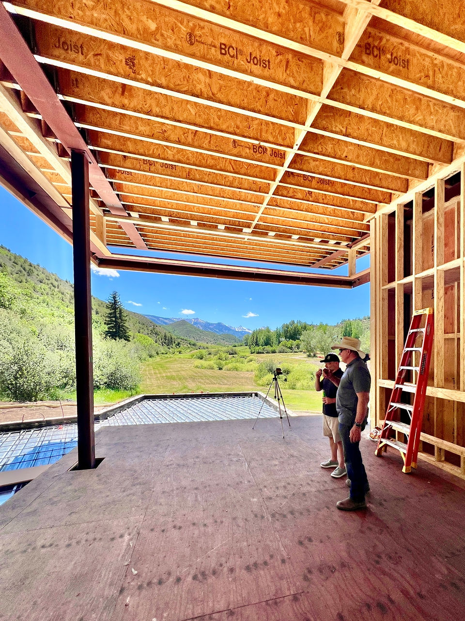 Design team reviewing mountain views from the future great room of a custom Aspen-area home during construction.