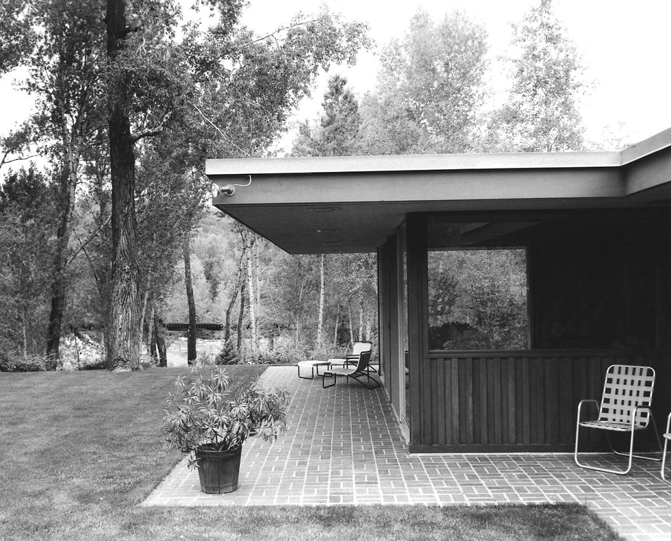 Exterior of Field Residence's rear yard featuring Aspen's Roaring Fork River and Mid-Century Modern charm.