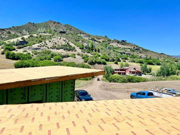 Construction progress at Brush Creek Ranch with views of the surrounding hillside homes and rural landscape between Aspen and Snowmass Village.