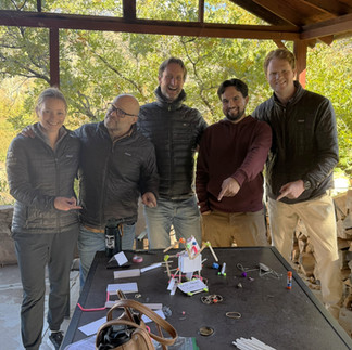 A Z Group Architecture team cluster showcasing their finished prototype made from craft supplies during a hands-on design challenge activity.