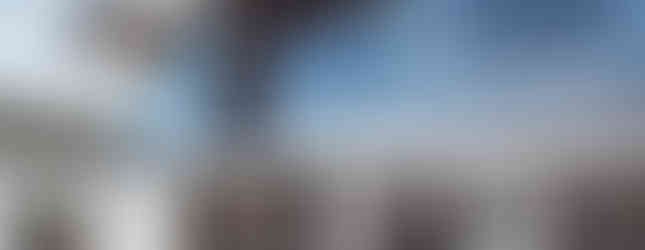 Sleek outdoor living space with snow-covered patio and glass balcony, blending indoor-outdoor design elements.