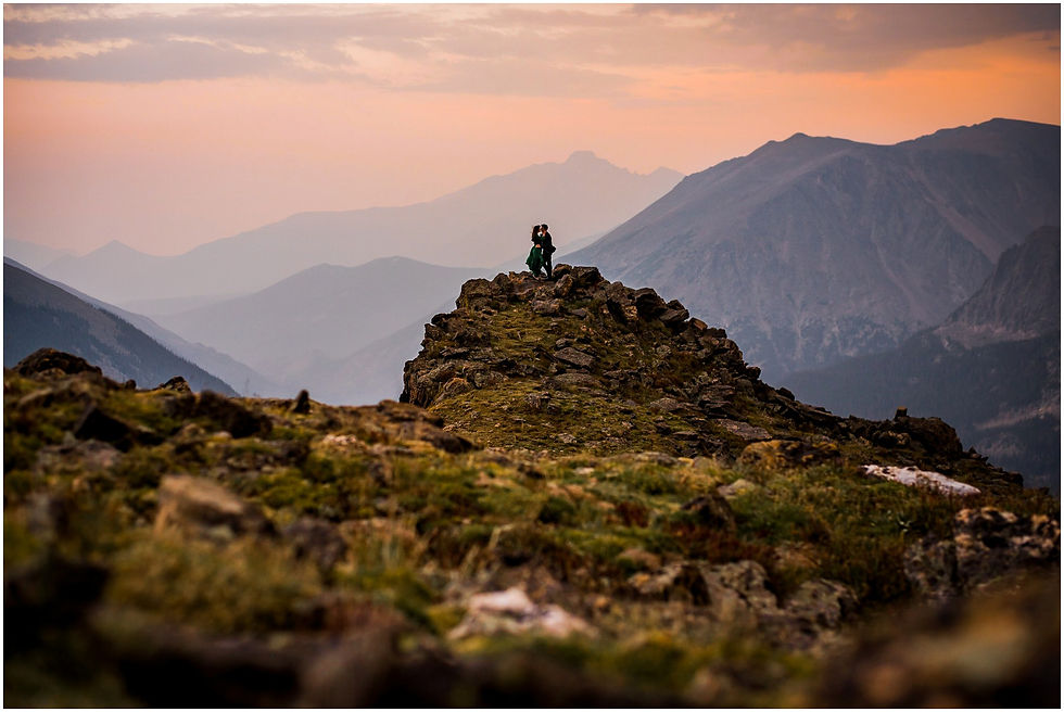 A couple holdomg hands with the astonishing views of the Rocky Mountain National Park in Colorado as their backdrop.