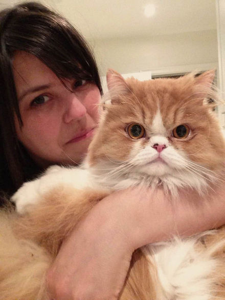 Woman holding a fluffy ginger cat with pet detective tips