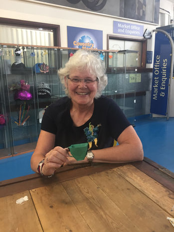 A photo of a woman who attended my workshop. She is holding an origami teacup that she has made.