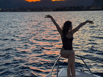 Guest enjoying sunset catamaran tour in Palermo with golden light over the sea