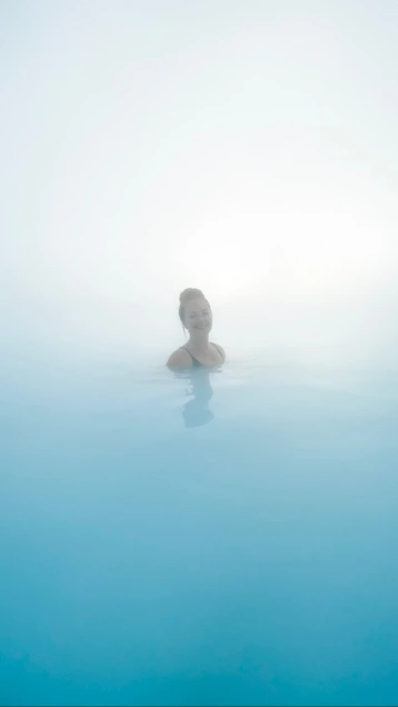 Girl surrounded by fog and blue water at the blue lagoon