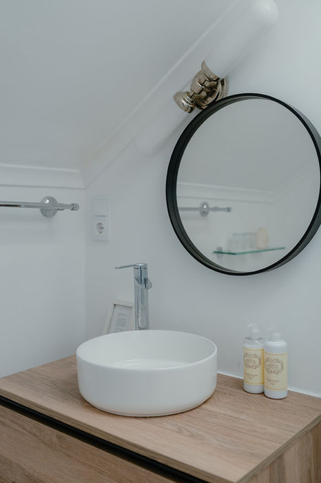 Modern bathroom sink and round mirror in dog-friendly stays Alentejo coast