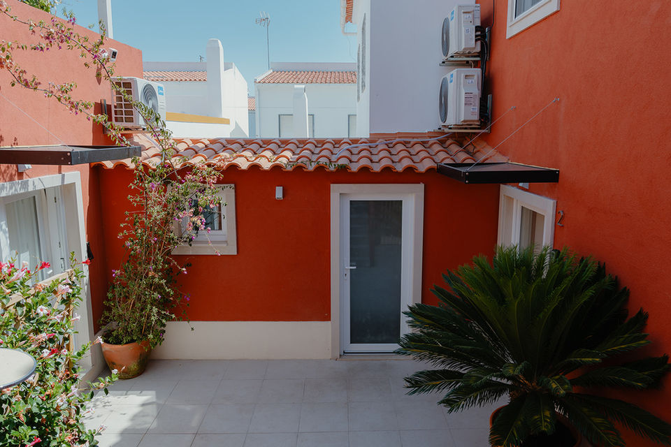 Terrace of a luxury aparthotel portugal with red walls.