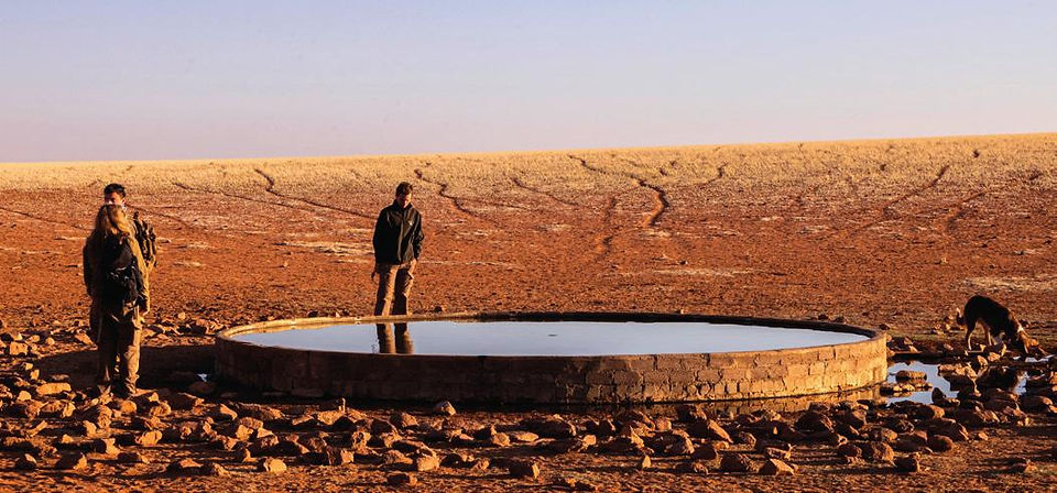 People standing around waterhole