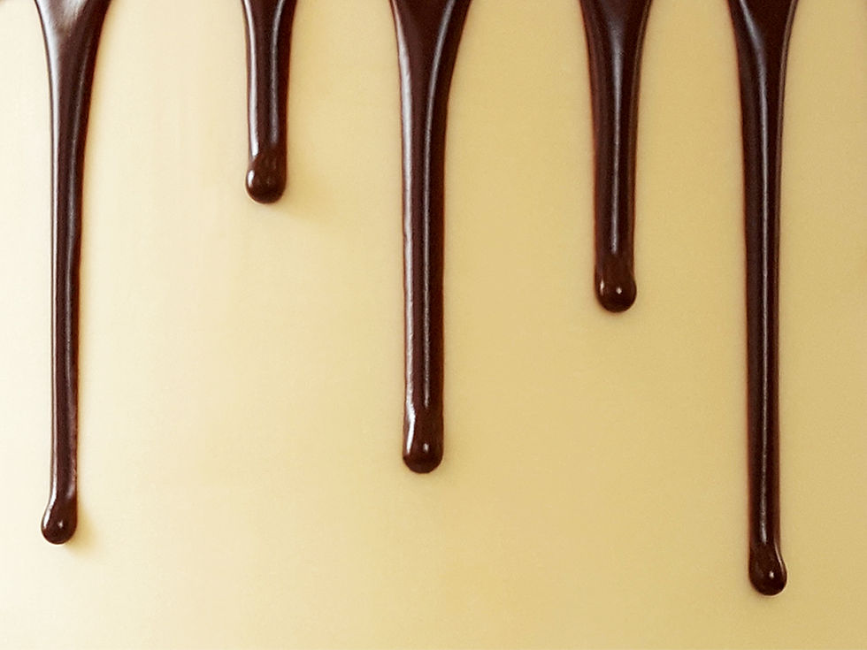 Glossy dark chocolate drip on a smooth cake