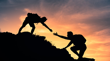 People helping each other up a mountain. Helping hand and teamwork concept. .jpg