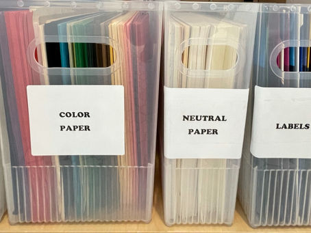 clear plastic bins with labels identifying the color coded papers sorted in each bin