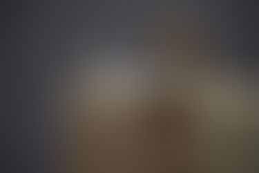 two figures - one sitting upright, the second lying on the thighs of the first - on a wood square