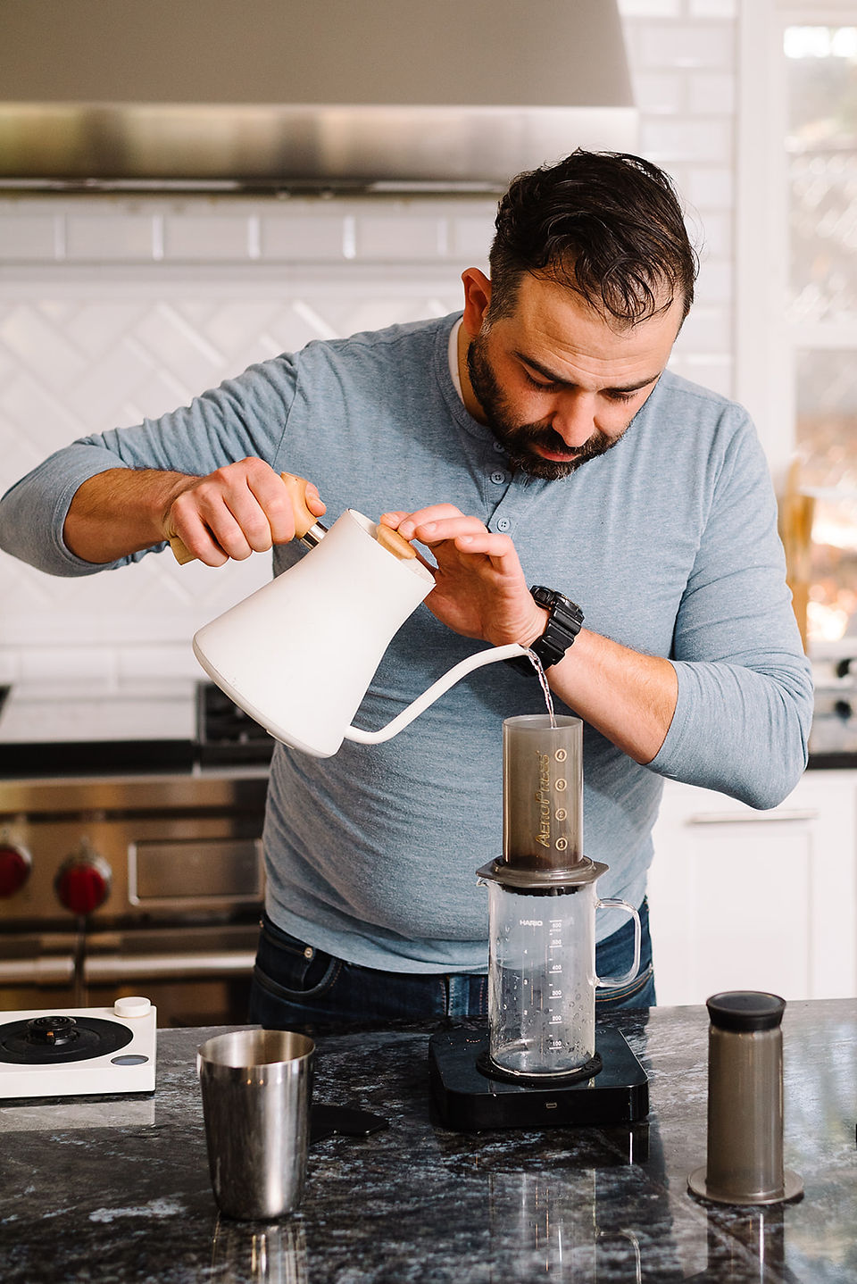 Man pouring hot water into the Aeropress to brew coffee