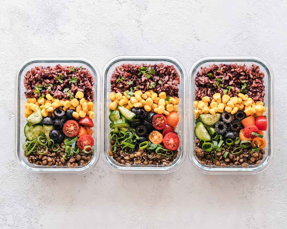 Three glass containers with rice, lentils and vegetables, which is a healthier option when heating food than plastic containers.