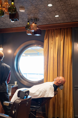 Groom Getting Groomed in Hooks Barbery aboard the Disney Wish captured by Disney Cruise Wedding Photographer Adrianna Gunn