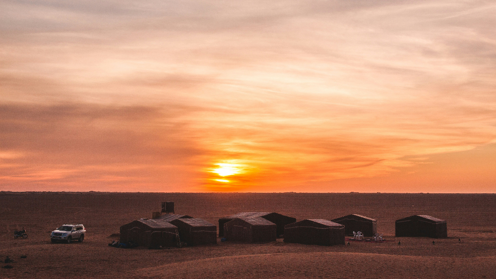 a desert camp in the moroccan desert during sunset