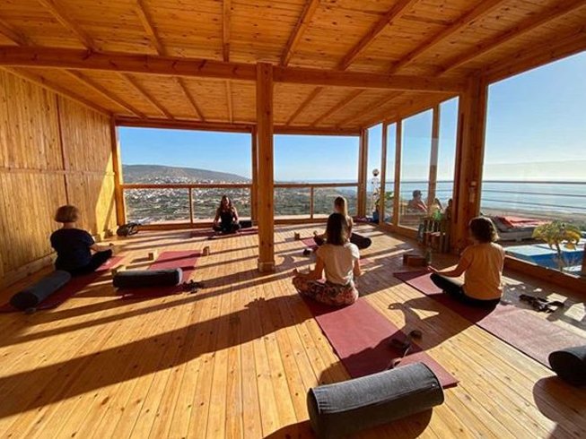 group of people enjoying yoga in a sunny day on amouage hotel terrace in taghazout morocco