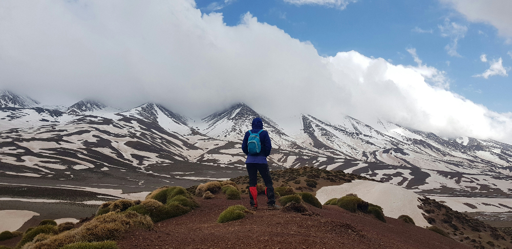 snowy atlas mountains in morocco and a man enjoying a hiking trip