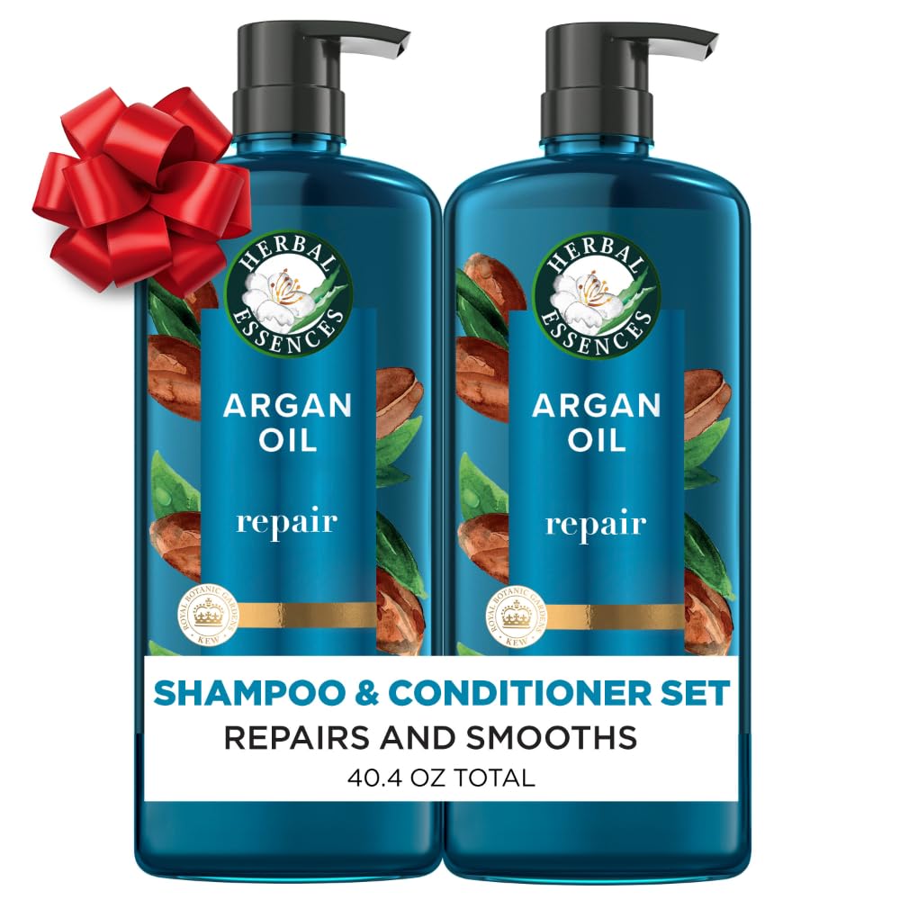Two blue Herbal Essences Argan Oil shampoo and conditioner bottles with red bow; text: ‘Repairs and Smooths, 40.4 oz total.’