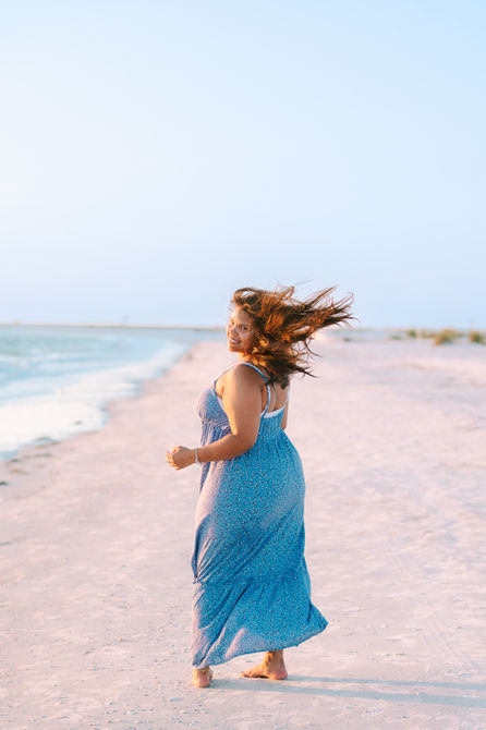 Senior girl walking on beach at sunset during portraits