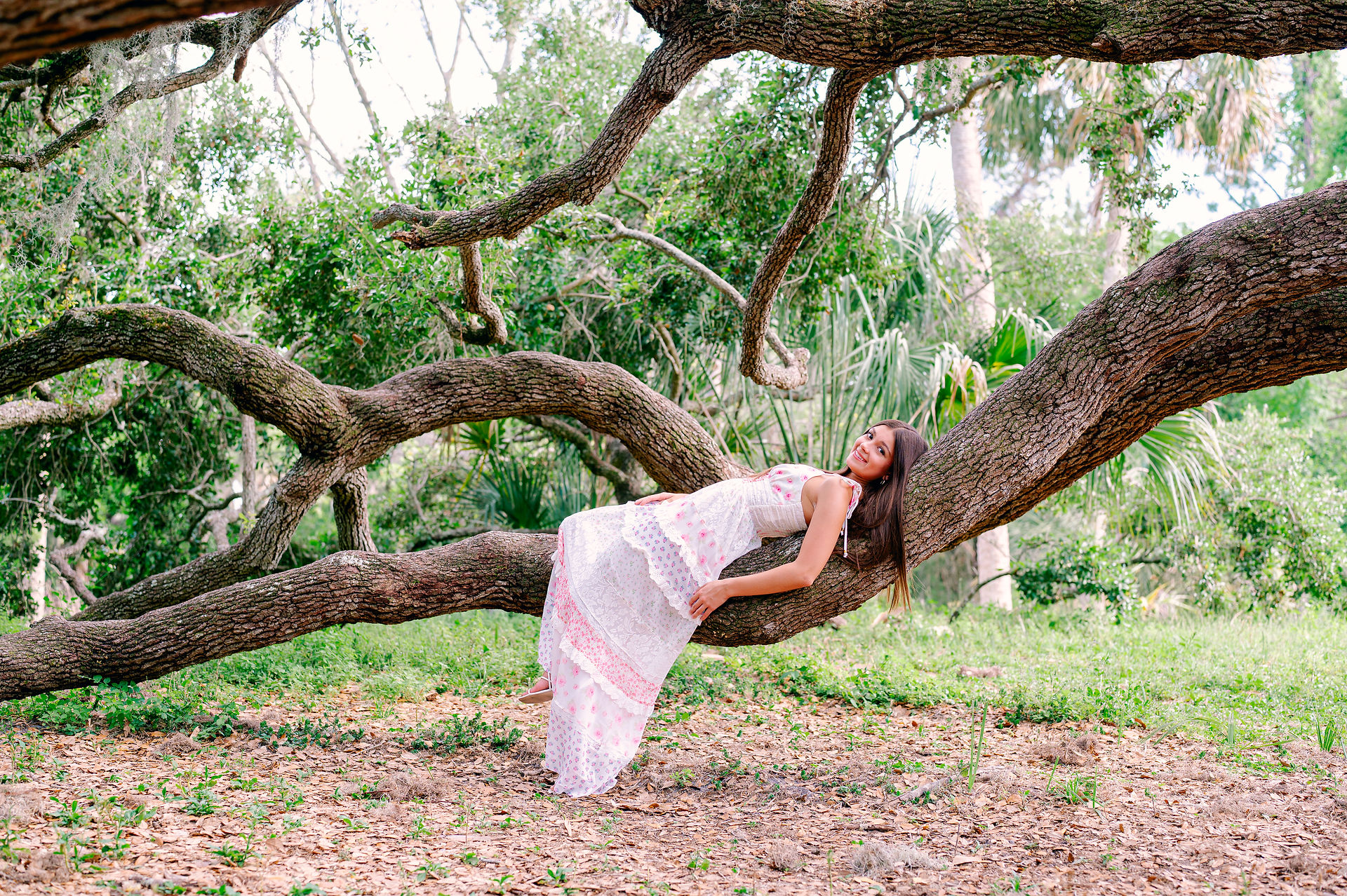 Floral dress twirl captured mid-spin by Tampa senior portrait photographer Nina Bashaw in Philippe Park