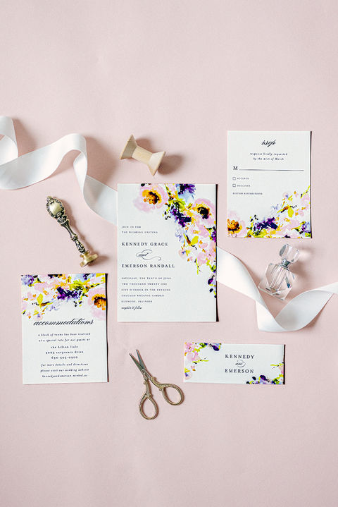 Flat lay of wedding details including invitation suite, rings, and florals styled in soft natural light during a Florida wedding