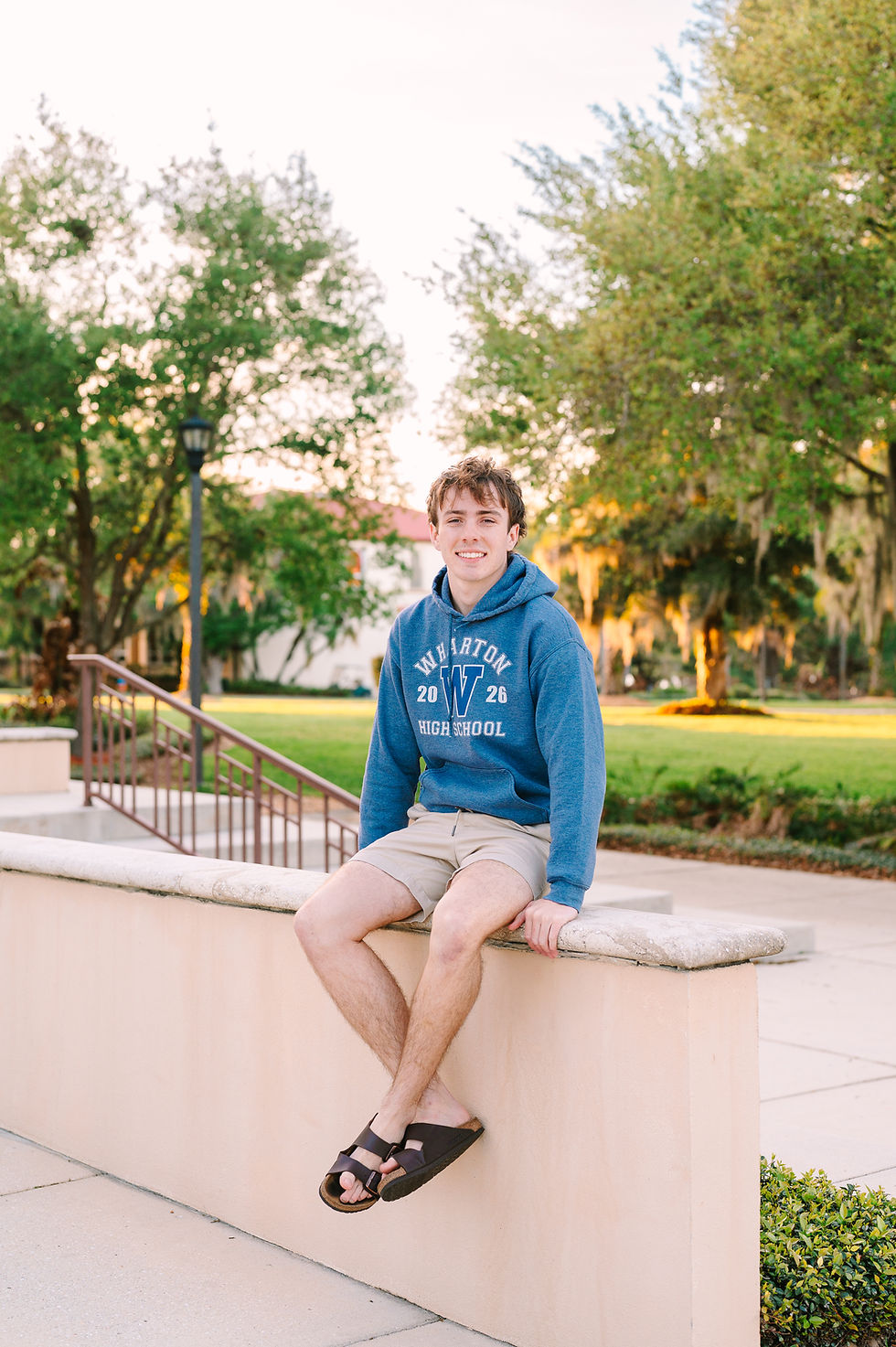 Senior boy posing at St. Leo University with a confident expression, photographed by Tampa senior portrait photographer Nina Bashaw with timeless collegiate scenery.