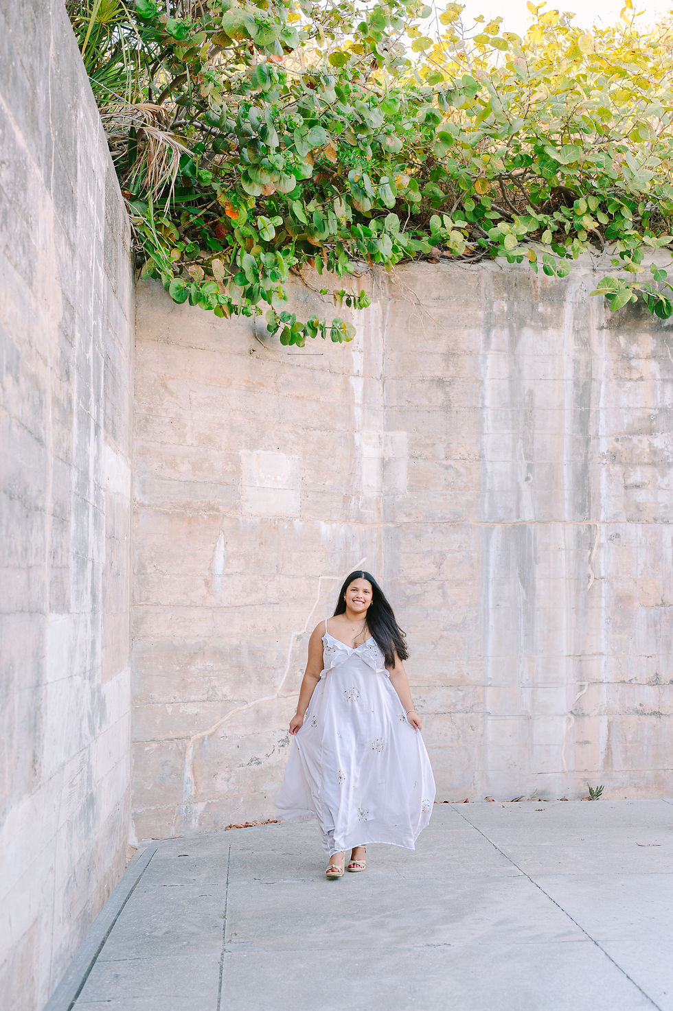 Candid senior portrait in Fort De Soto greenery with trees and natural foliage surrounding the subject during a Tampa senior photography session by Nina Bashaw
