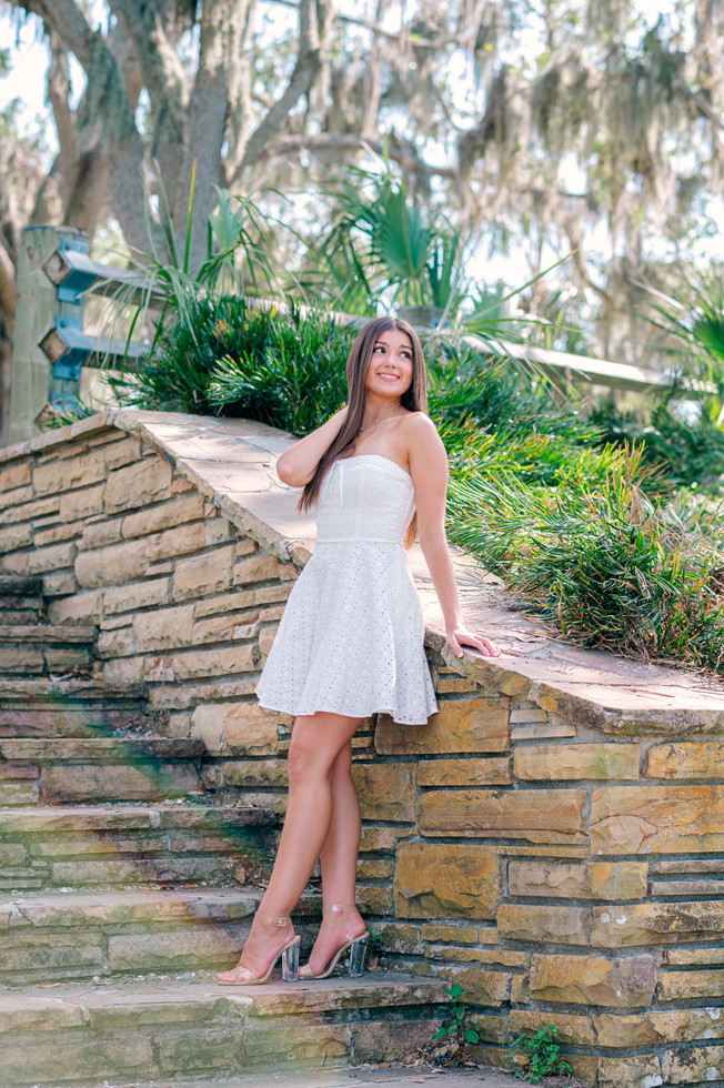Senior girl smiling in white sundress with Spanish moss background photographed in Philippe Park by Tampa senior portrait photographer Nina Bashaw